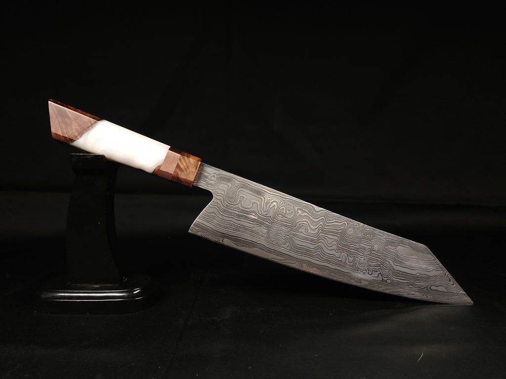 Chef knife with Damascus pattern on a stand with a dark background.