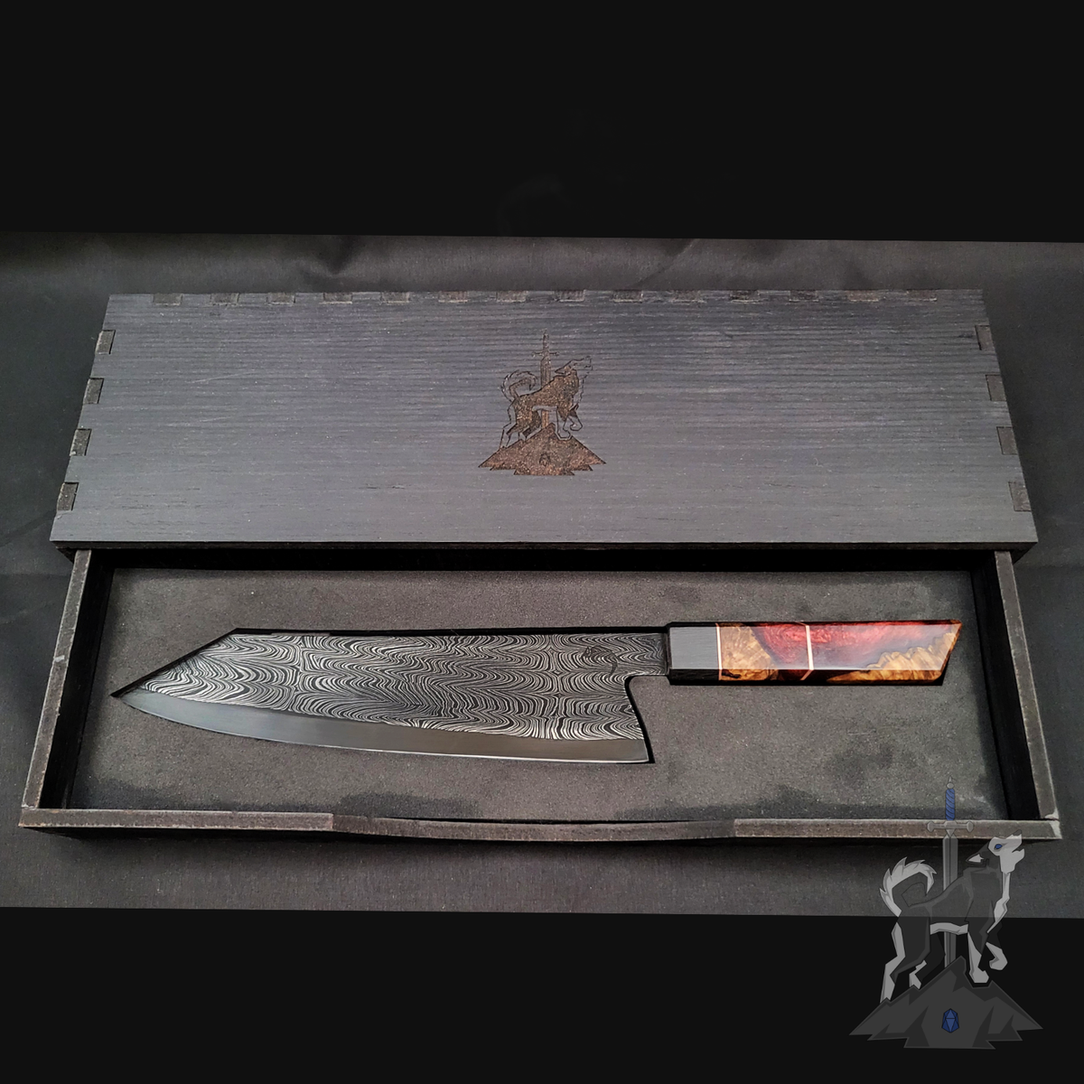 Damascus chef's knife in a wooden box with engraved design on a dark background