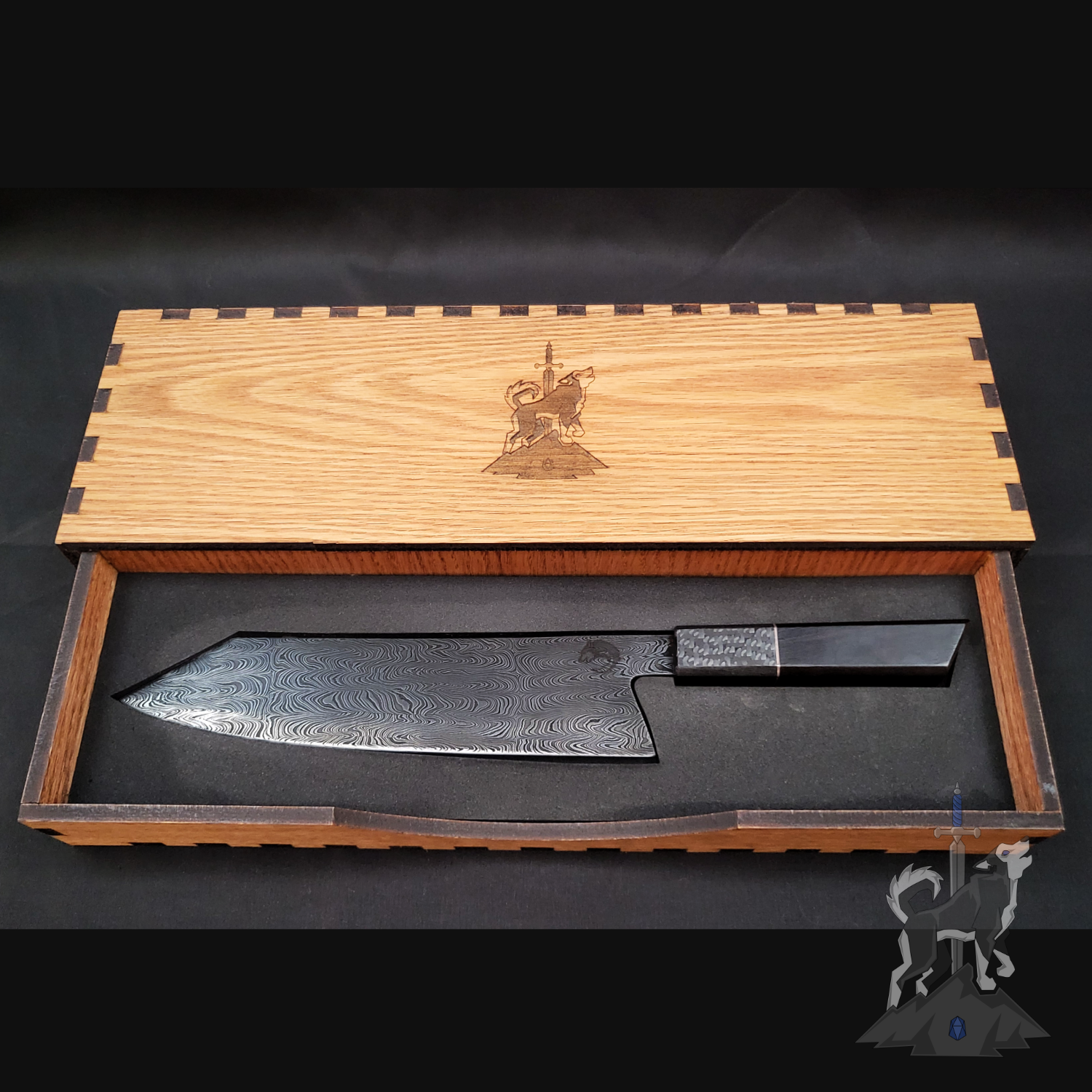 Damascus chef's knife in a wooden box with engraved design on a dark background