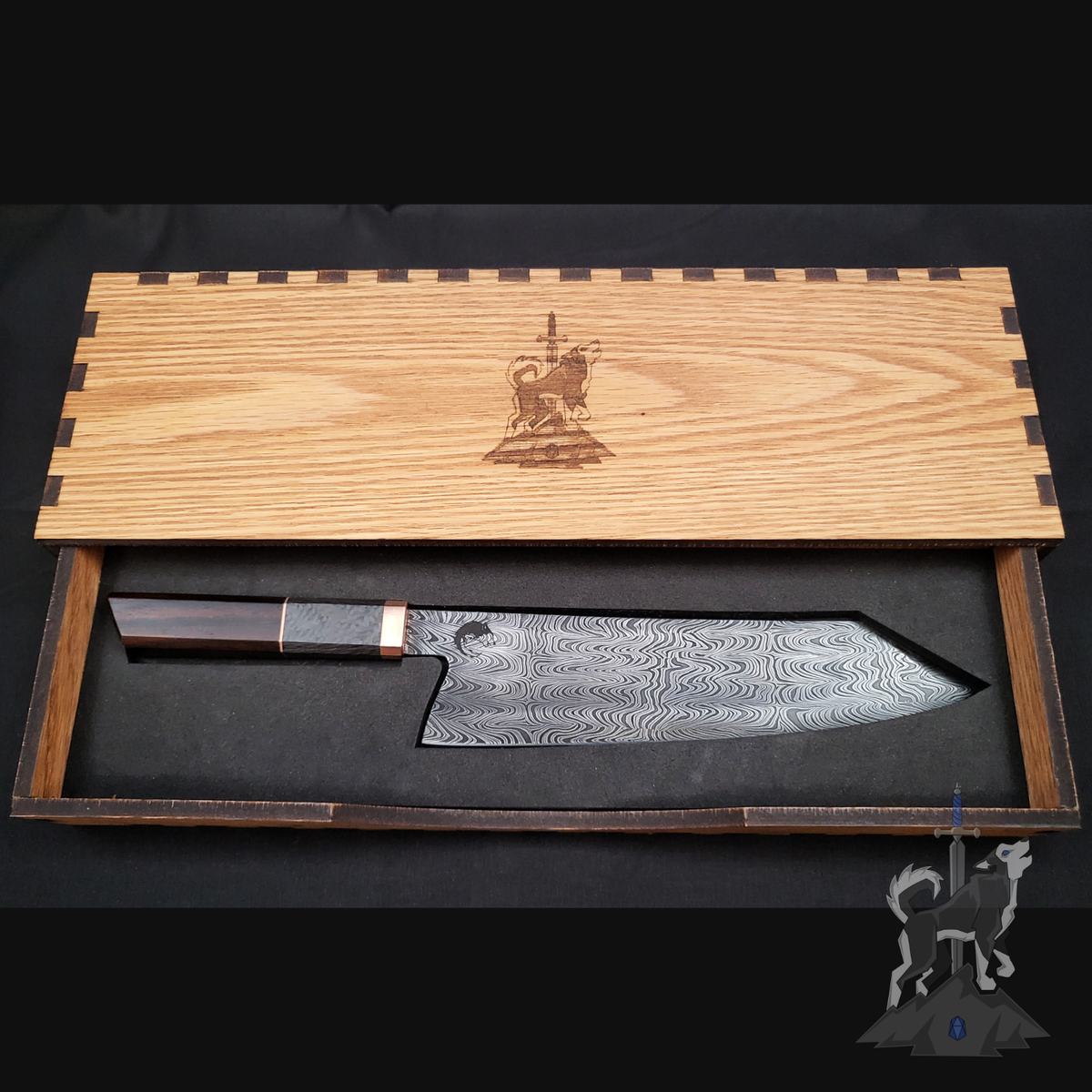 Damascus chef's knife in a wooden box with engraved design on a dark background