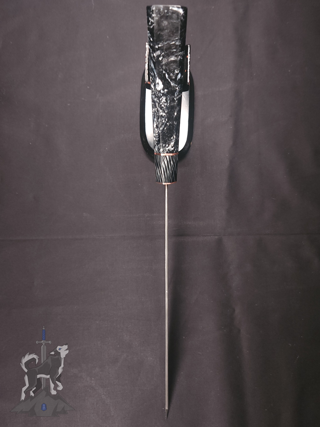 Image from overhead of the top of Damascus chef knife on a dark background