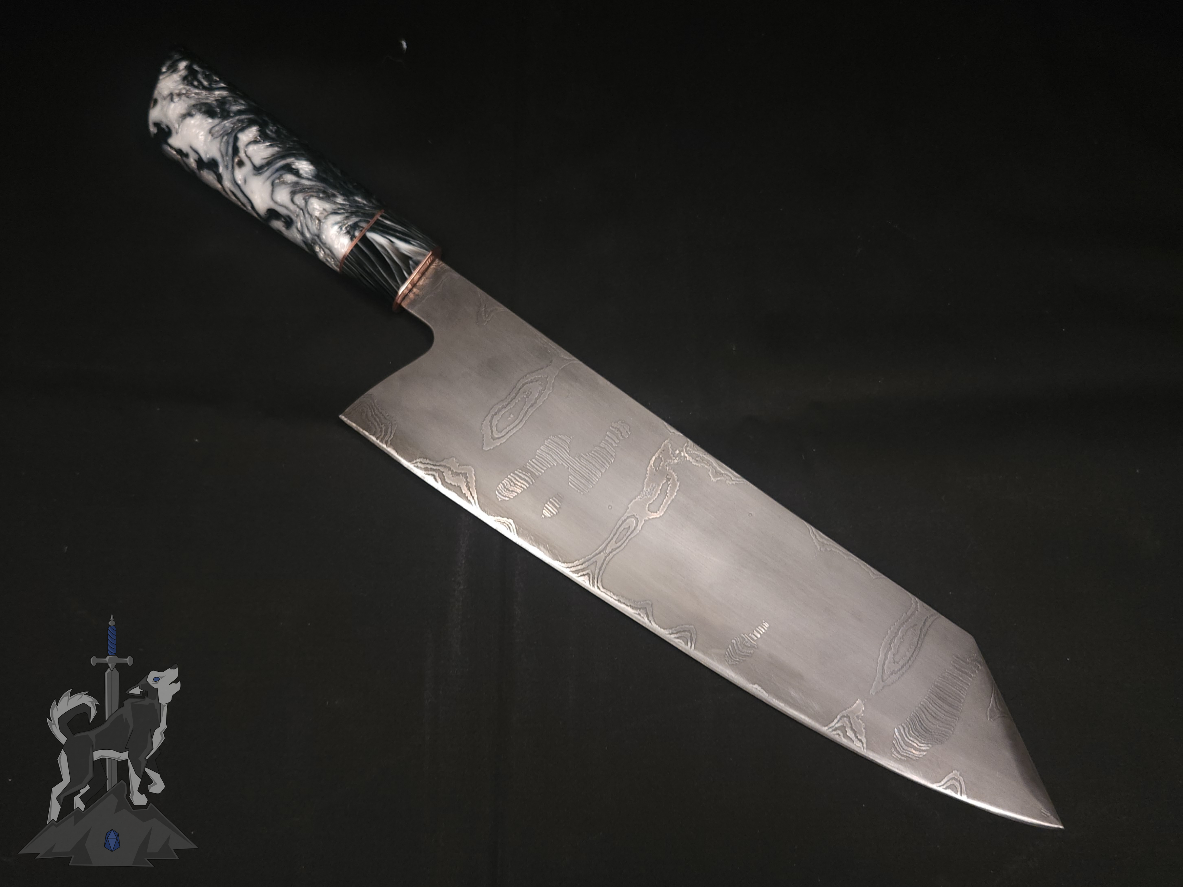 Chef knife with Damascus pattern laying on a dark background.