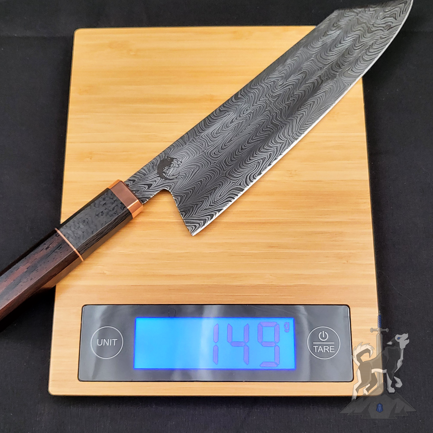 Chef's knife with a damascus pattern on a digital kitchen scale displaying weight.