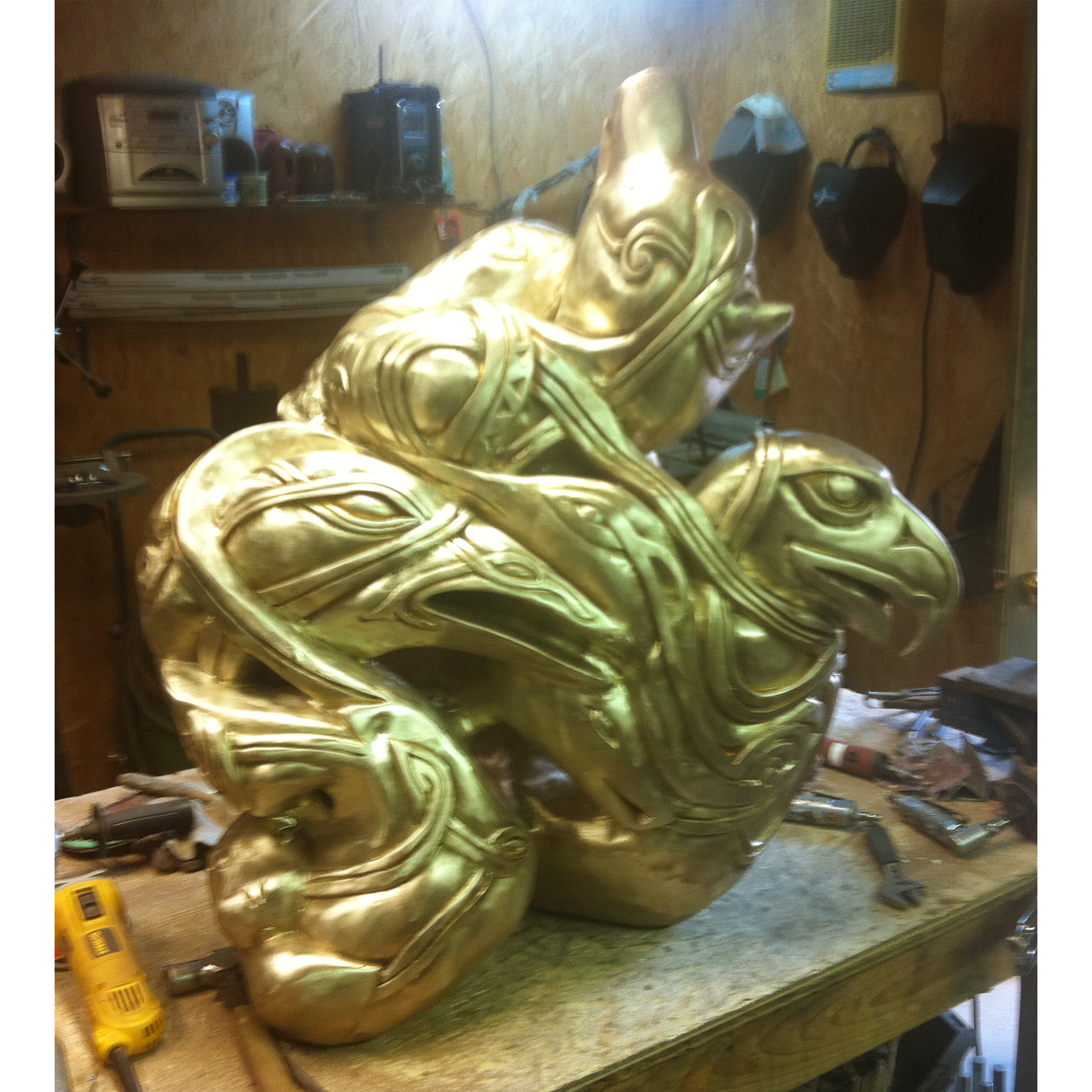 Bronze sculpture recreation of multiple animals together in an Inuit style in a workshop setting