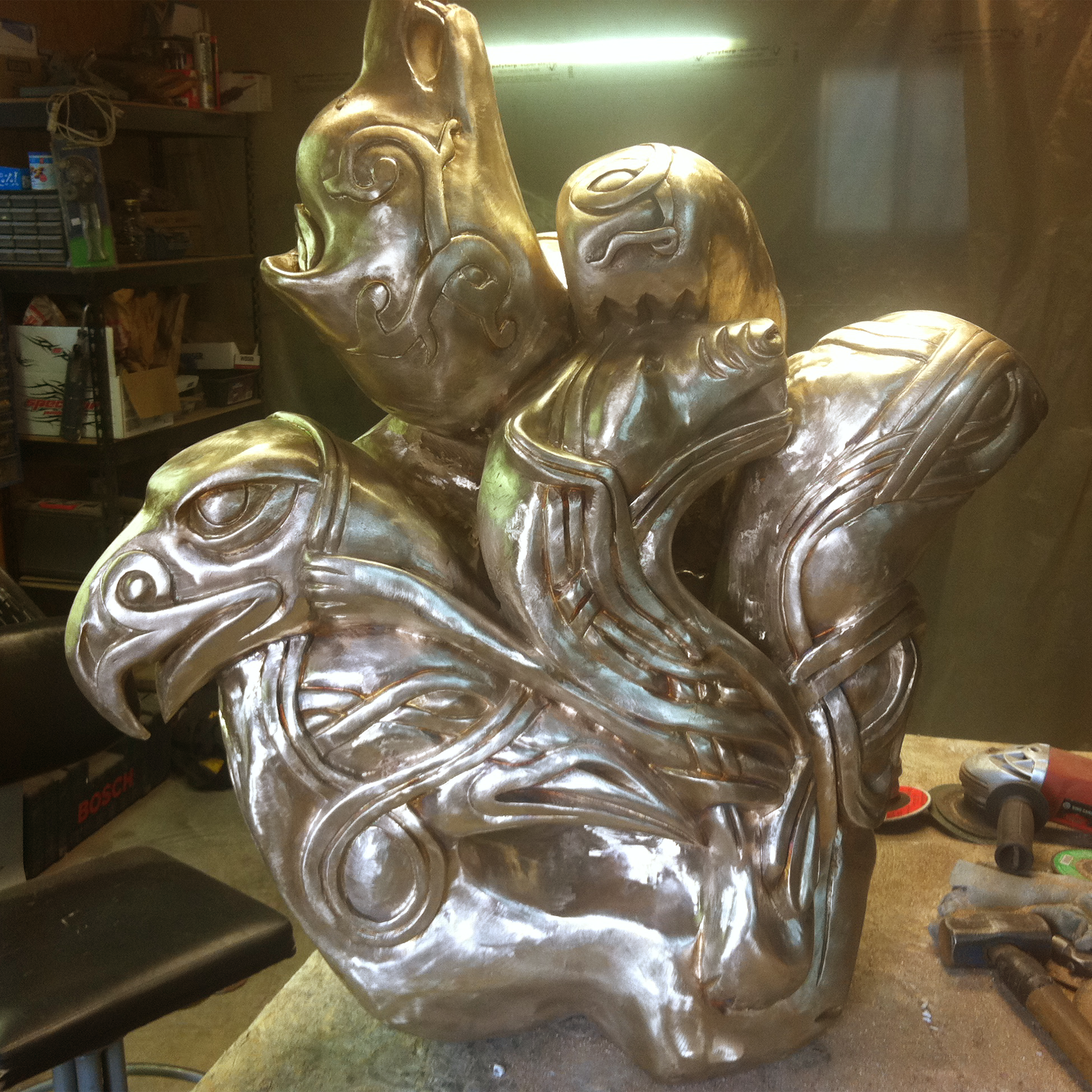 Bronze sculpture recreation of multiple animals together in an Inuit style in a workshop setting