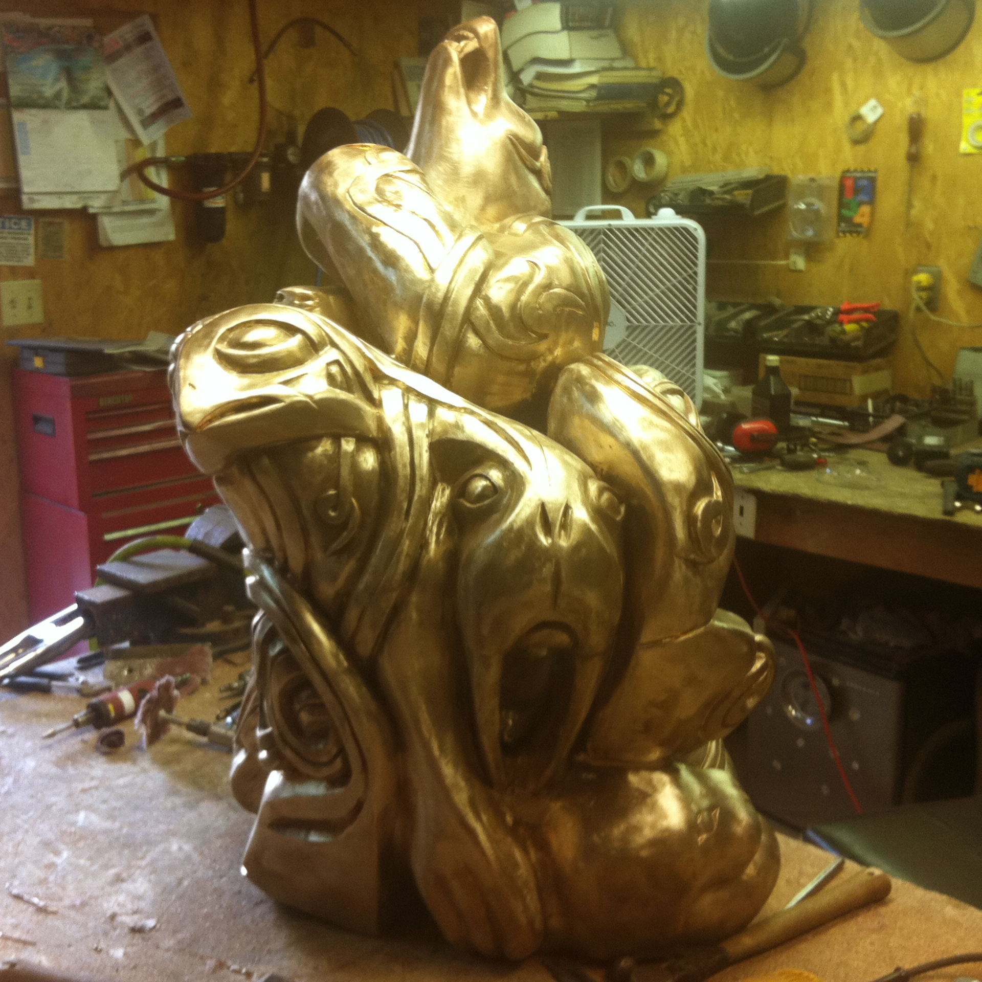 Bronze sculpture recreation of multiple animals together in an Inuit style in a workshop setting