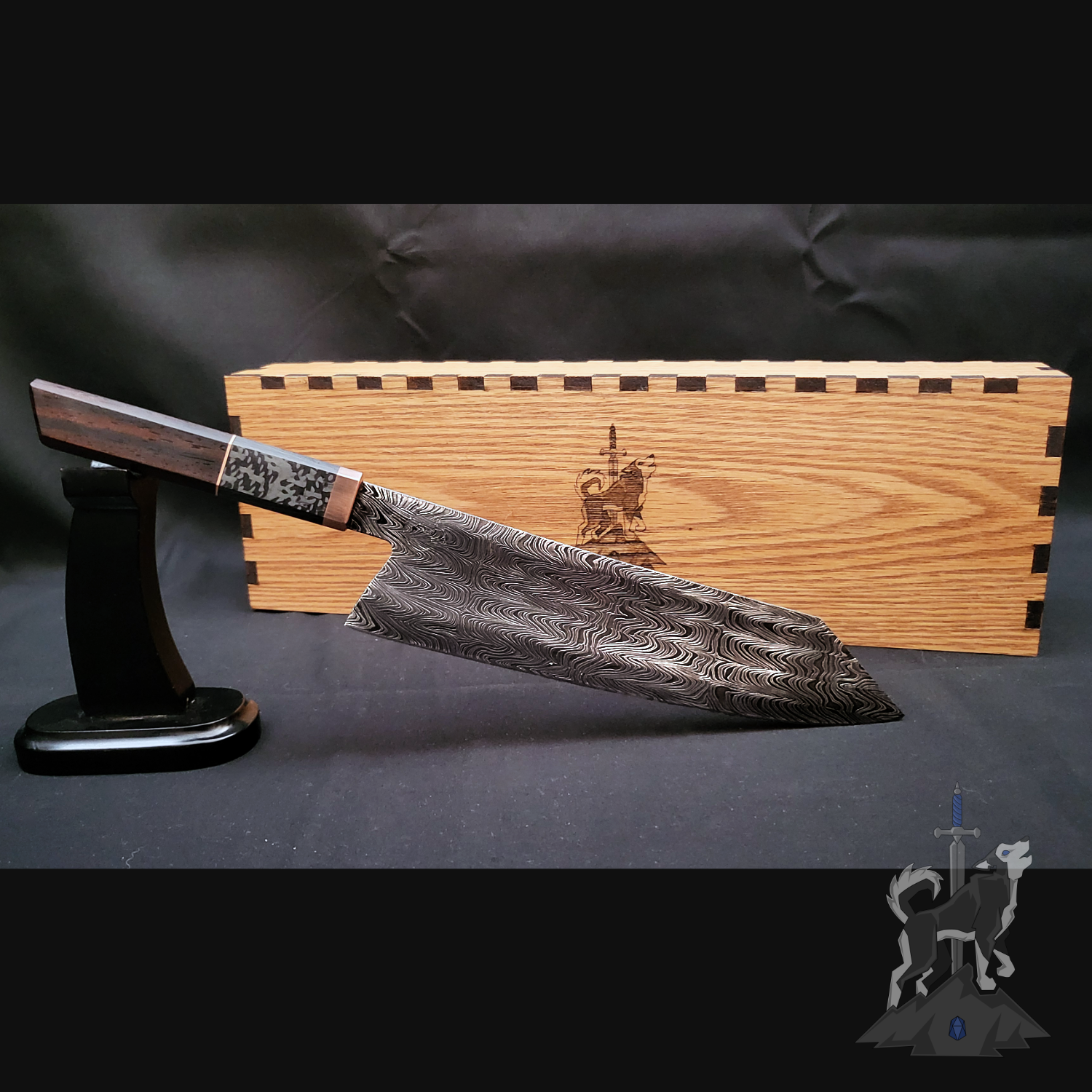 Chef knife with Damascus pattern on a stand next to a wooden box on a dark background