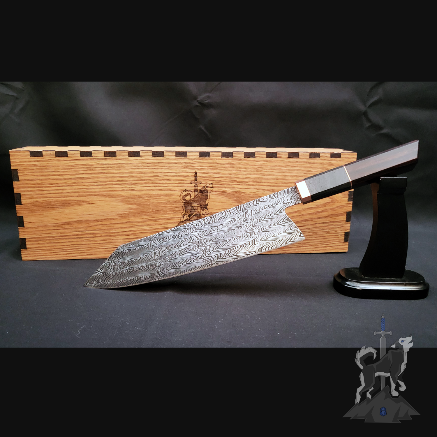 Chef knife with Damascus pattern on a stand next to a wooden box on a dark background